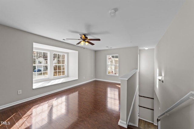 unfurnished room with a ceiling fan, baseboards, and wood finished floors