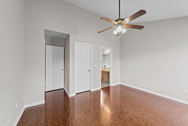 unfurnished bedroom featuring ensuite bathroom, high vaulted ceiling, wood finished floors, and baseboards