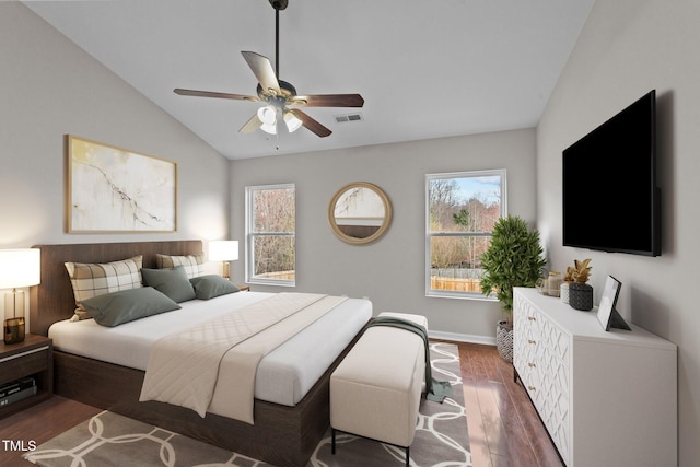 bedroom with vaulted ceiling, multiple windows, dark wood finished floors, and visible vents