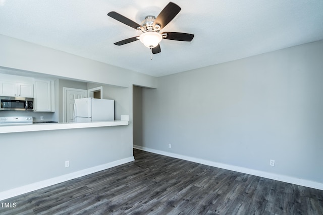 unfurnished living room featuring dark wood-style floors, ceiling fan, and baseboards