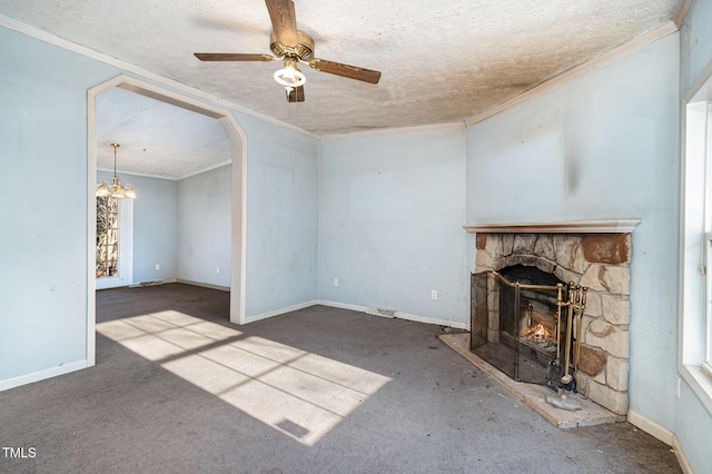 unfurnished living room with crown molding, ceiling fan with notable chandelier, a textured ceiling, and a stone fireplace