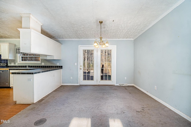 kitchen featuring pendant lighting, a textured ceiling, white cabinetry, a chandelier, and crown molding