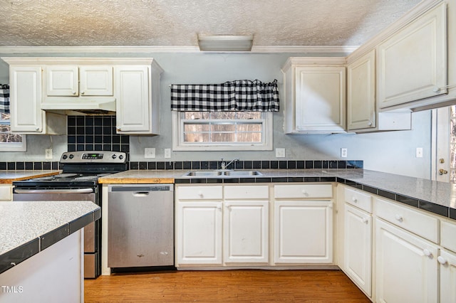 kitchen with light hardwood / wood-style floors, sink, crown molding, and stainless steel appliances