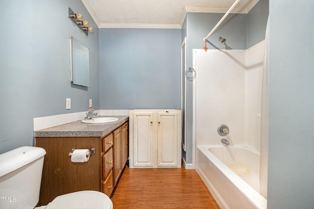 full bathroom with hardwood / wood-style flooring, bathtub / shower combination, toilet, vanity, and ornamental molding