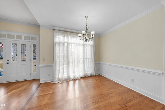 foyer entrance featuring crown molding, a chandelier, and hardwood / wood-style flooring