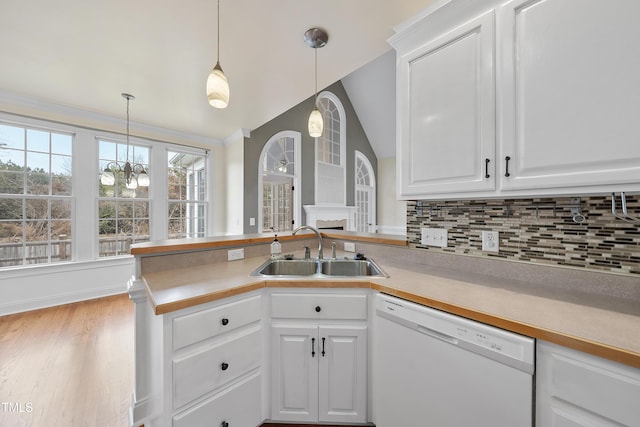 kitchen featuring sink, dishwasher, white cabinetry, backsplash, and decorative light fixtures