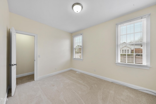 spare room with light colored carpet and a healthy amount of sunlight