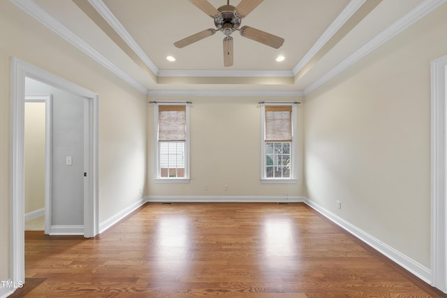 unfurnished room featuring crown molding, hardwood / wood-style floors, ceiling fan, and a tray ceiling