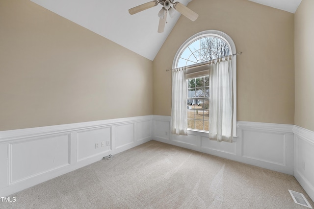 carpeted empty room with ceiling fan and vaulted ceiling