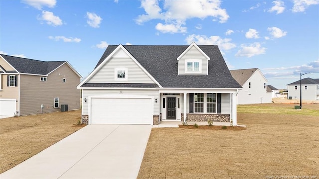 view of front of house with covered porch, a front yard, a garage, and central air condition unit