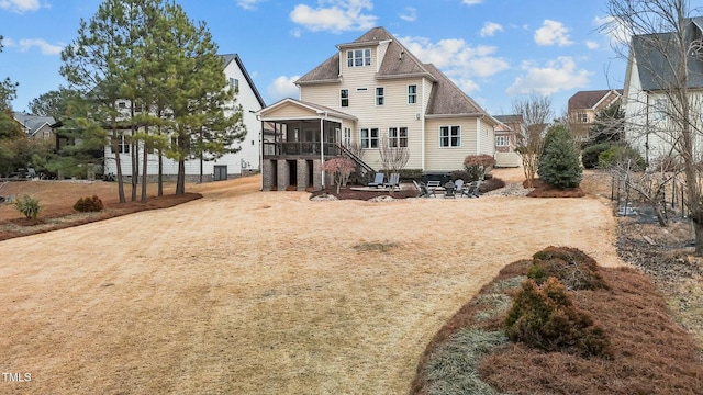 rear view of property featuring a patio and a sunroom