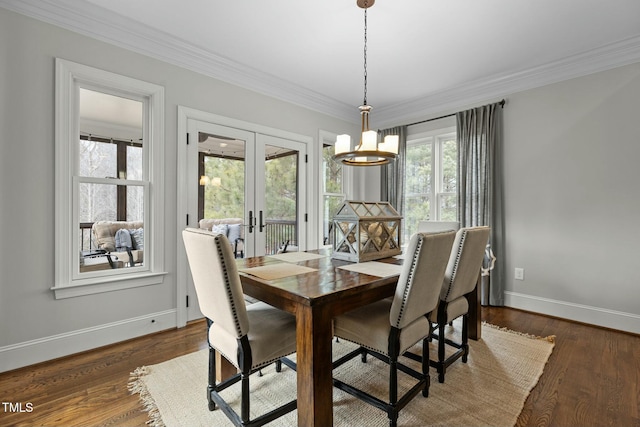 dining room featuring dark wood-type flooring, ornamental molding, and french doors