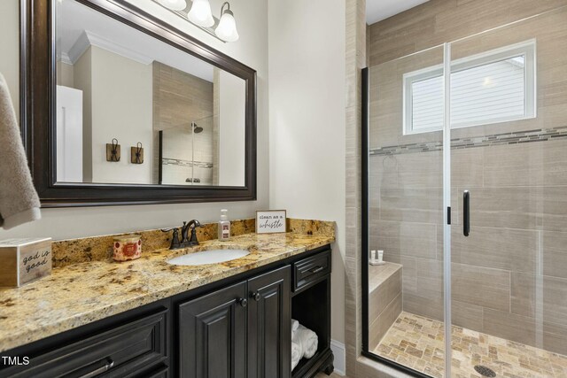 bathroom featuring vanity, crown molding, and walk in shower