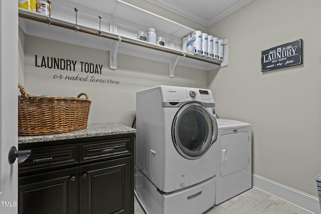 laundry room featuring cabinets, ornamental molding, and washing machine and clothes dryer