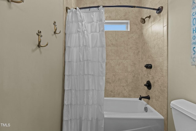 bathroom featuring shower / tub combo and toilet