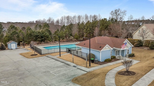 exterior space with a shed, central AC unit, and a lawn