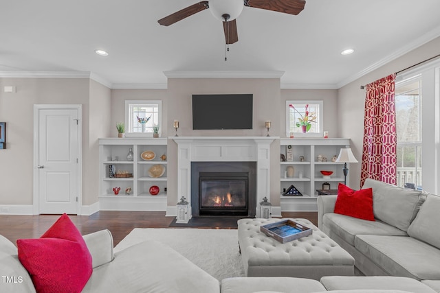 living room featuring crown molding, recessed lighting, a fireplace with flush hearth, wood finished floors, and baseboards