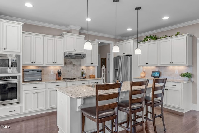 kitchen featuring under cabinet range hood, crown molding, stainless steel appliances, and dark wood finished floors