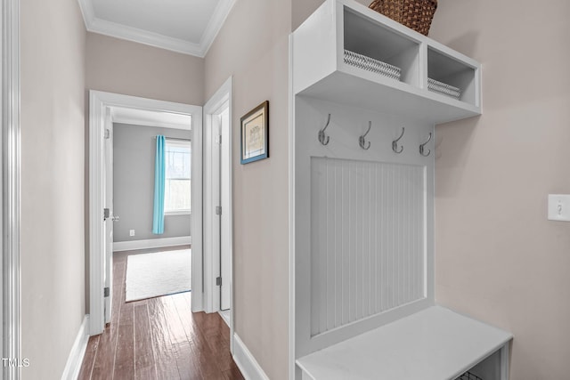 mudroom with dark wood-style floors, baseboards, and crown molding