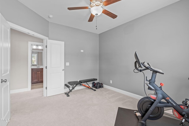 exercise room with ceiling fan, baseboards, and light colored carpet