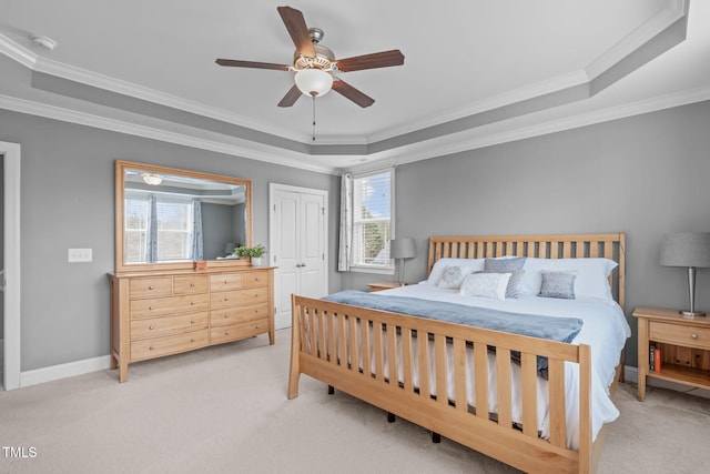 bedroom with light carpet, multiple windows, a tray ceiling, and ornamental molding