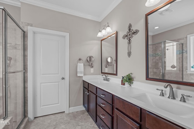 bathroom featuring a shower stall, double vanity, a sink, and crown molding