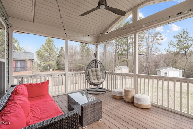 sunroom / solarium featuring ceiling fan, vaulted ceiling, and a wealth of natural light