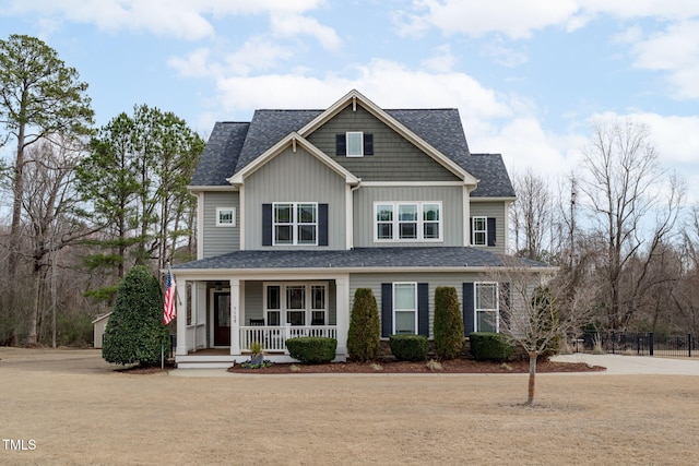 view of front facade featuring board and batten siding, fence, and covered porch