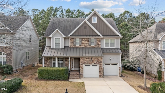 craftsman-style house with a standing seam roof, driveway, board and batten siding, and stone siding