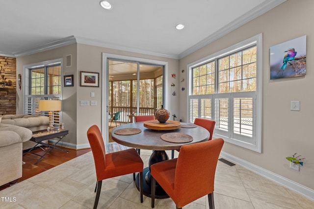 dining room featuring baseboards, visible vents, and ornamental molding