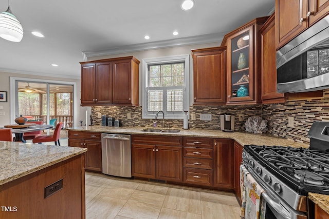 kitchen with a sink, stainless steel appliances, light stone counters, and a wealth of natural light