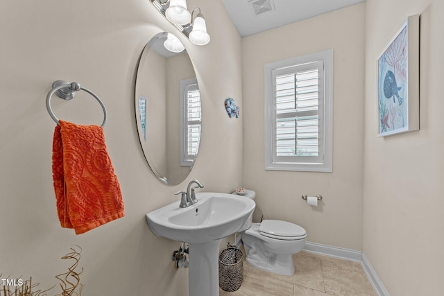 bathroom with visible vents, baseboards, toilet, tile patterned floors, and a sink