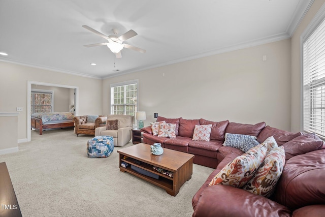 living room featuring a wealth of natural light, light colored carpet, crown molding, and ceiling fan