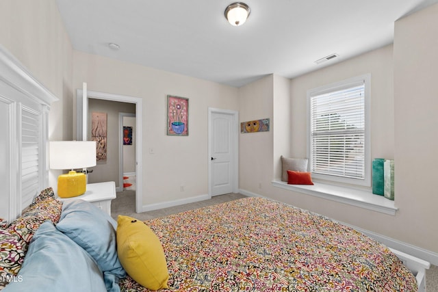 carpeted bedroom featuring baseboards and visible vents