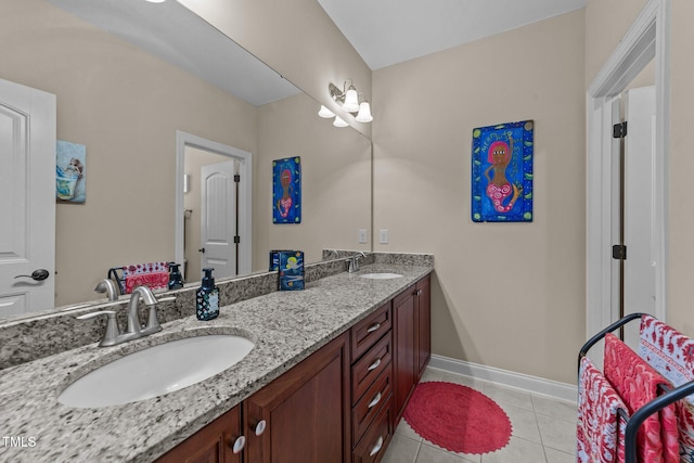 bathroom featuring tile patterned flooring, double vanity, baseboards, and a sink