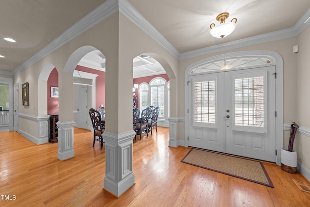 foyer entrance with light wood-type flooring, french doors, and crown molding