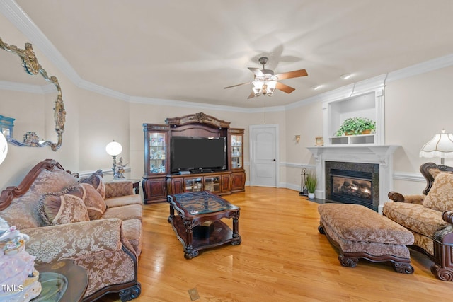 living room featuring light wood-type flooring, ceiling fan, and ornamental molding