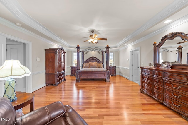 bedroom with light hardwood / wood-style floors, a raised ceiling, ceiling fan, and ornamental molding