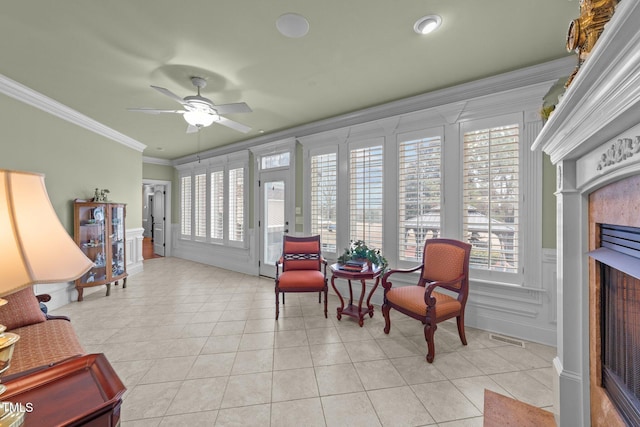 interior space with ceiling fan, ornamental molding, and light tile patterned floors