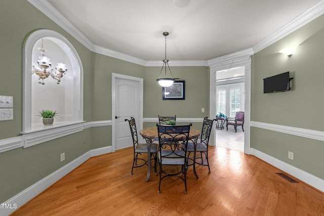 dining area featuring crown molding and light hardwood / wood-style floors