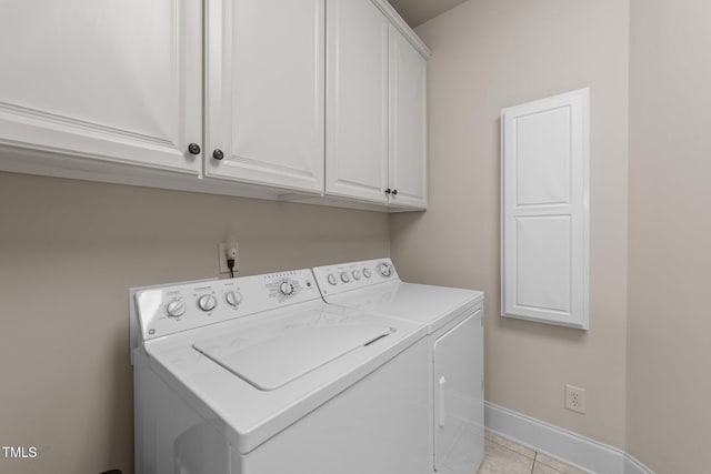 laundry room featuring light tile patterned floors, cabinets, and washer and dryer