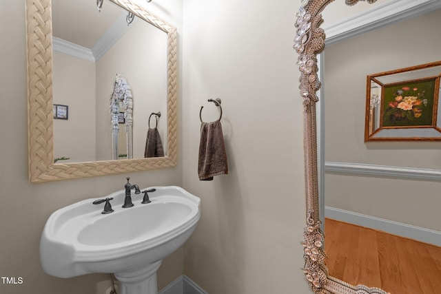 bathroom with hardwood / wood-style flooring, sink, and crown molding