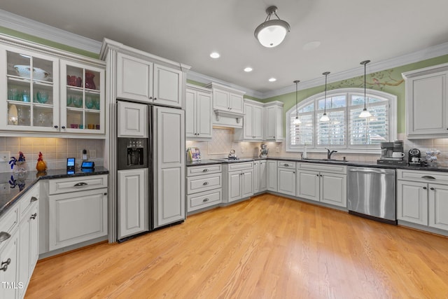 kitchen featuring light hardwood / wood-style flooring, dishwasher, hanging light fixtures, sink, and paneled built in fridge