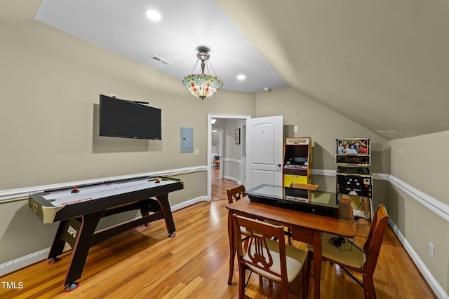 interior space featuring light wood-type flooring, vaulted ceiling, and electric panel