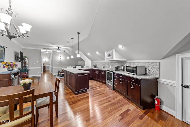 kitchen featuring appliances with stainless steel finishes, lofted ceiling, decorative light fixtures, kitchen peninsula, and light hardwood / wood-style flooring