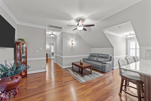 living room featuring ceiling fan, crown molding, lofted ceiling, and wood-type flooring