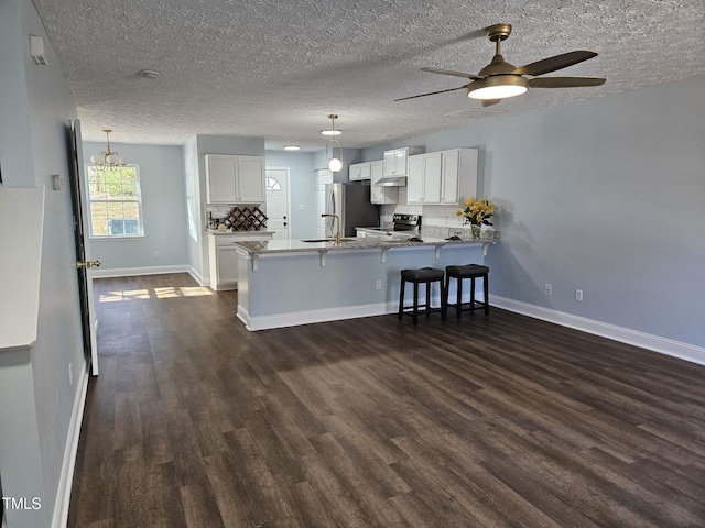 kitchen with appliances with stainless steel finishes, white cabinetry, decorative light fixtures, kitchen peninsula, and ceiling fan