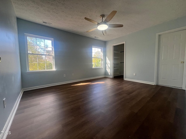 unfurnished bedroom with ceiling fan, dark hardwood / wood-style floors, and a textured ceiling