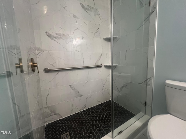 bathroom with toilet and a tile shower