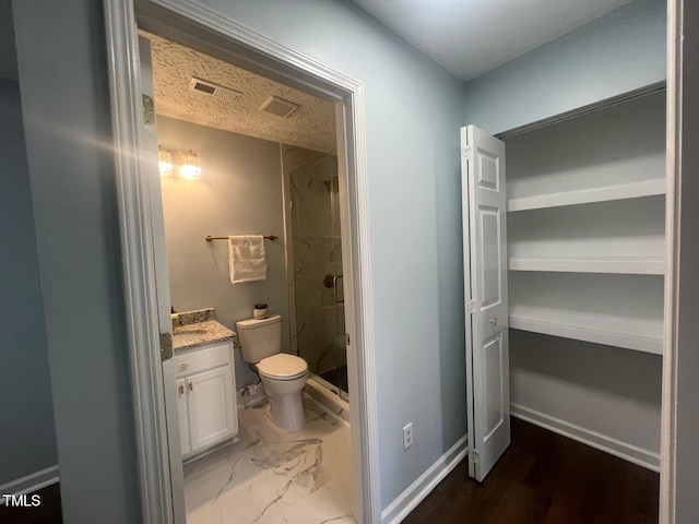 bathroom with toilet, a shower with door, and vanity